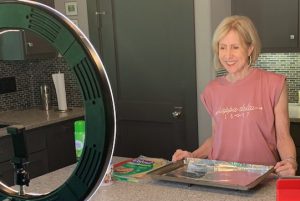 Dietitian Speaker Neva Cochran films a cooking demo in her kitchen.