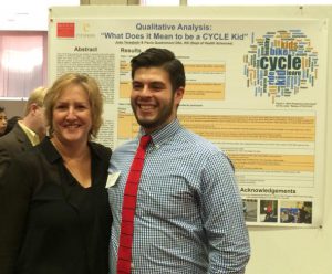 Dietitian Speaker Paula Quatromoni stands in front of a poster presentation at a professional conference.