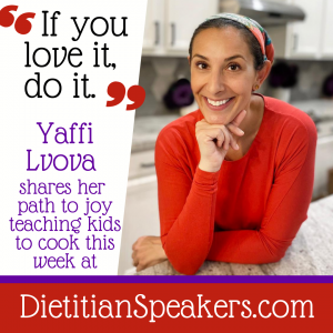 Dietitian Speaker Yaffi Lvova leans on her kitchen counter wearing a long-sleeved orange top and a pretty head covering. She's smiling at her audience and ready to teach cooking.